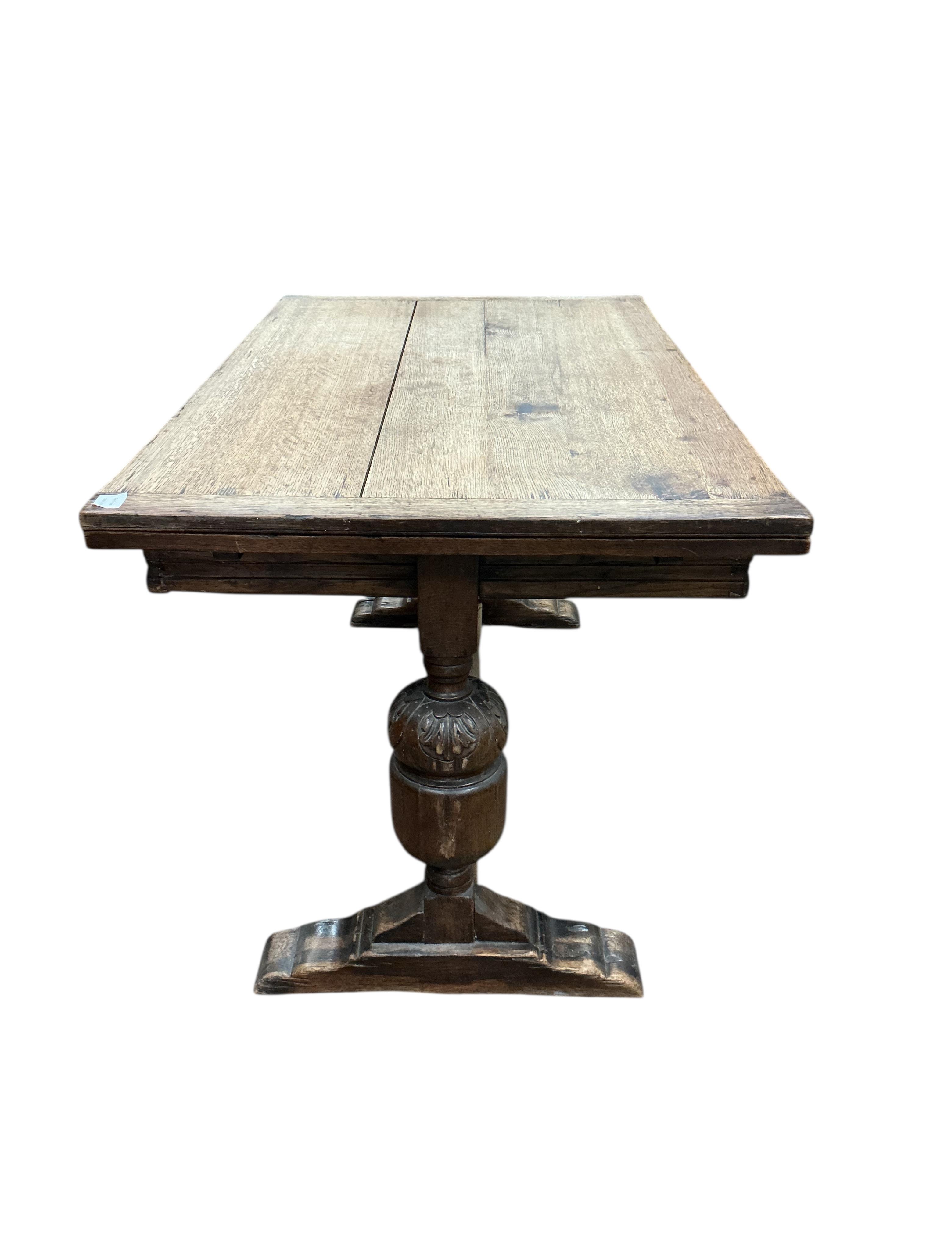 An 18th century style rectangular oak extending draw leaf refectory table, width 136cm, depth 80cm, height 78cm together with four carved oak dining chairs